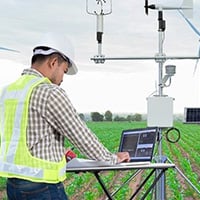 A man in a hard hat and safety vest stands near solar panel , highlighting the importance of renewable energy sources.